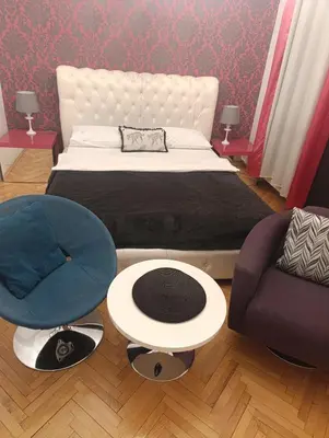 a bedroom with a bed and a couch and a chair at TITO in Belgrade