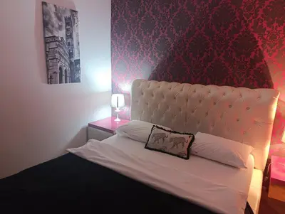 a bedroom with a white bed with a red wall at TITO in Belgrade