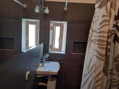 a bathroom with a sink and two windows at TITO in Belgrade