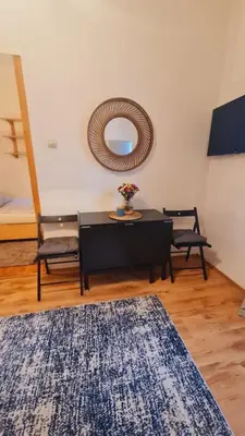 a living room with a table and a mirror at Beogradjanka CITY CENTAR cozy apartment in Belgrade