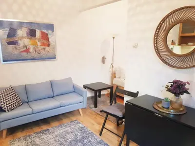 a living room with a blue couch and a mirror at Beogradjanka CITY CENTAR cozy apartment in Belgrade