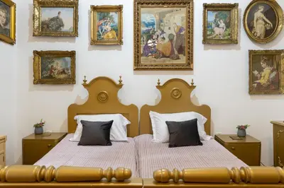 a bedroom with two beds and paintings on the wall at Natalie's Gallery in Belgrade