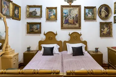 a bedroom with a bed with paintings on the wall at Natalie's Gallery in Belgrade