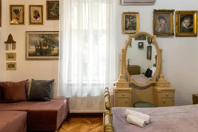a room with a mirror and a bed and a couch at Natalie's Gallery in Belgrade