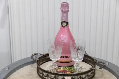 a pink bottle and two glasses on a tray at Natalie's Gallery in Belgrade