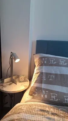 a bed with a lamp on a table next to it at Apartman u Zemunu in Zemun
