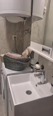 a bathroom sink with a basket on top of it at Apartman u Zemunu in Zemun