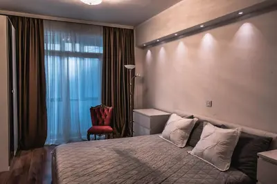 a bedroom with a bed and a red chair at Athens Apartment City Center in Belgrade