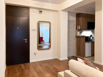 a living room with a couch and a mirror at Athens Apartment City Center in Belgrade