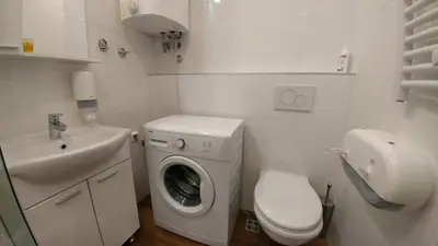 a small bathroom with a washing machine and a sink at Decanska Apartments in Belgrade