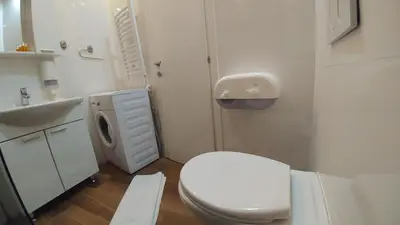a white bathroom with a toilet and a sink at Decanska Apartments in Belgrade