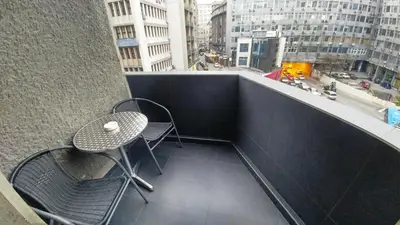 a table and chairs on the balcony of a building at Decanska Apartments in Belgrade