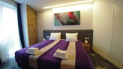 a bedroom with a purple bed with towels on it at Decanska Apartments in Belgrade