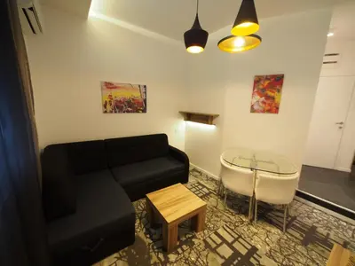 a living room with a black couch and a table at Decanska Apartments in Belgrade