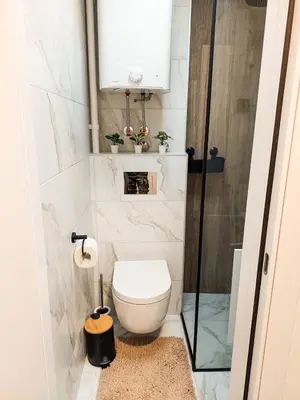 a small bathroom with a toilet and a window at Azulejo Apartment in Novi Beograd