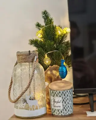 a desk with a glass jar and a christmas tree at Azulejo Apartment in Novi Beograd