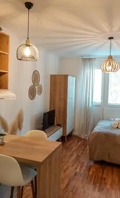 a bedroom with a bed and a table and chairs at Azulejo Apartment in Novi Beograd