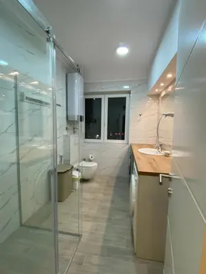 a bathroom with a shower and a sink and a toilet at Filmski grad Apartmani in Filmski Grad