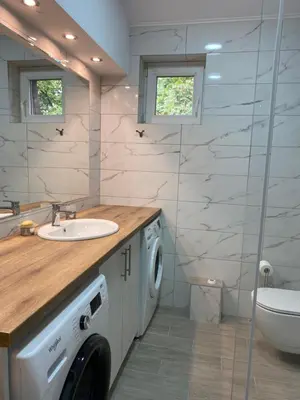 a bathroom with a sink and a washing machine at Filmski grad Apartmani in Filmski Grad