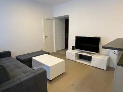 a living room with a couch and a flat screen tv at Filmski grad Apartmani in Filmski Grad