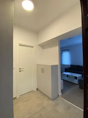 an empty living room with a door and a couch at Filmski grad Apartmani in Filmski Grad