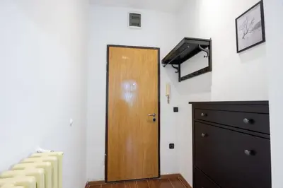 a wooden door in a room with a dresser at Belgrade Center Apartment Lux V in Belgrade