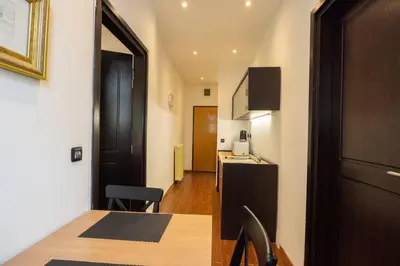a kitchen and a dining room with a table and a door at Belgrade Center Apartment Lux V in Belgrade