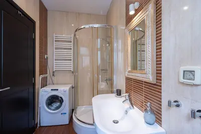 a bathroom with a sink and a washing machine at Belgrade Center Apartment Lux V in Belgrade