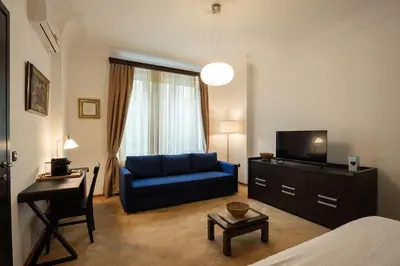 a living room with a blue couch and a television at Belgrade Center Apartment Lux V in Belgrade