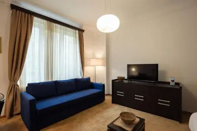 a living room with a blue couch and a tv at Belgrade Center Apartment Lux V in Belgrade