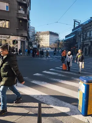 a man crossing a street in a busy city at Top Republic in Belgrade