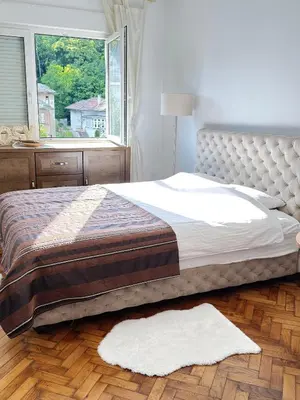 a bed in a bedroom with a large window at Cozy with parking in Zemun