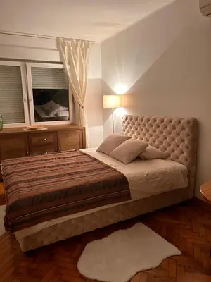 a large bed in a bedroom with a window at Cozy with parking in Zemun