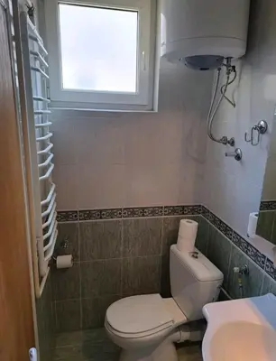 a small bathroom with a toilet and a window at Apartman 2001 Stari grad in Belgrade