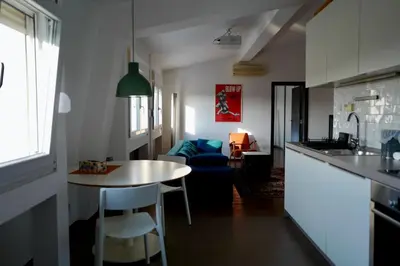 a kitchen and living room with a table and a couch at Apartment Norman Bates in Belgrade