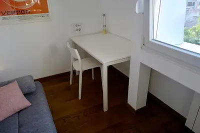 a white table and chair in a room with a window at Apartment Norman Bates in Belgrade