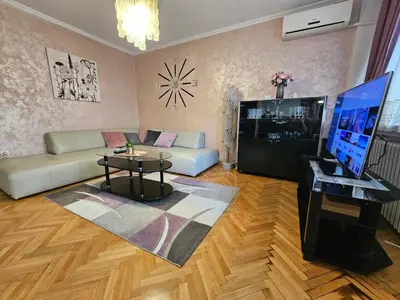 a living room with a couch and a tv at Slavija Apartment in Belgrade
