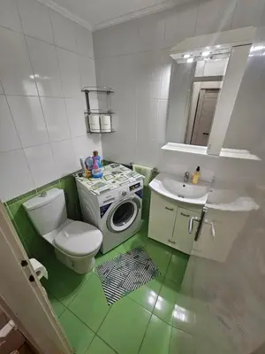 a bathroom with a toilet a sink and a washing machine at Slavija Apartment in Belgrade