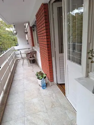 a balcony with a table and chairs on a porch at Slavija Apartment in Belgrade
