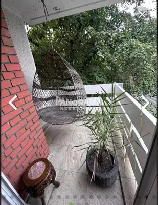 a patio with a swing and a potted plant at Slavija Apartment in Belgrade