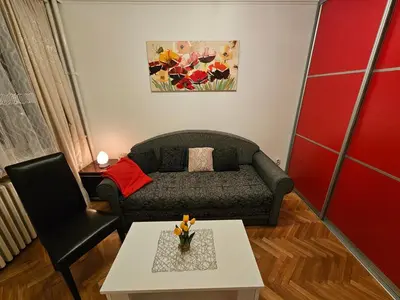 a living room with a couch and a table at Slavija Apartment in Belgrade