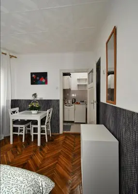 a living room with a table and a kitchen at Studio Sky in Belgrade
