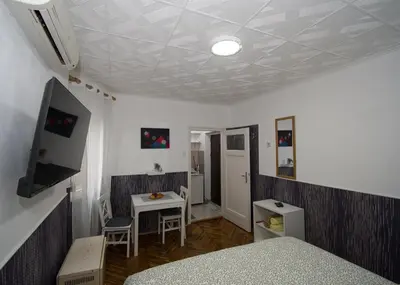 a room with a bed and a desk and a table at Studio Sky in Belgrade
