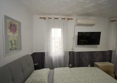a bedroom with a bed and a tv and a window at Studio Sky in Belgrade