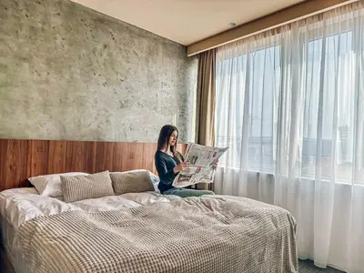 a woman sitting on a bed reading a newspaper at CIRCLE OF 2 in Belgrade