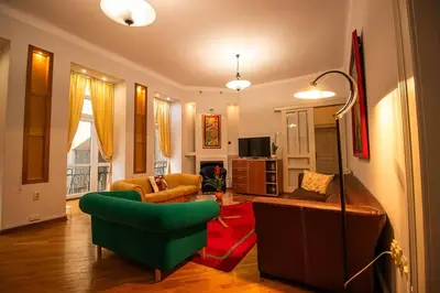 a living room with a green chair and a couch at King Peter Apartment in Belgrade