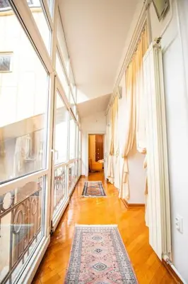 a hallway with a large window and a rug at King Peter Apartment in Belgrade