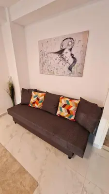 a brown couch in a living room with a painting at Apartman Laki in Tošin Bunar