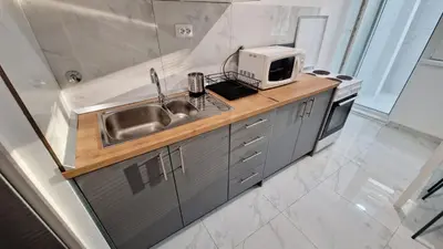 a kitchen with a sink and a microwave at Apartman Laki in Tošin Bunar