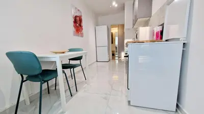 a kitchen with a table and chairs and a refrigerator at Apartman Laki in Tošin Bunar